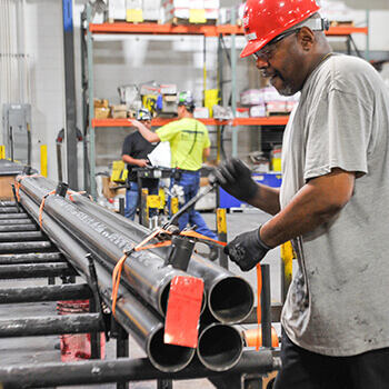 Workers in safety gear fabricating pipefittings